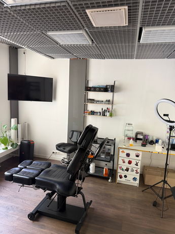 Professional tattoo artist workstation in Helsinki Finland featuring ergonomic black chair and advanced tattoo lighting equipment.
