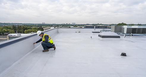 Roofing technician inspecting a white commercial flat roof in Houston