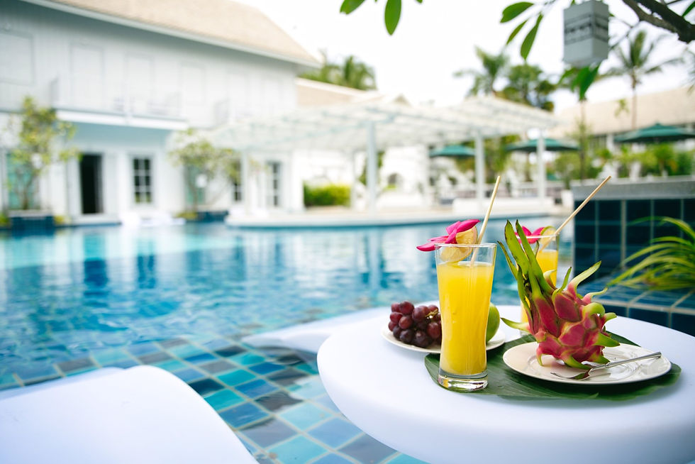 Refreshing tropical juices and fresh fruit served on a table beside the long swimming pool at MyBanLao hotel
