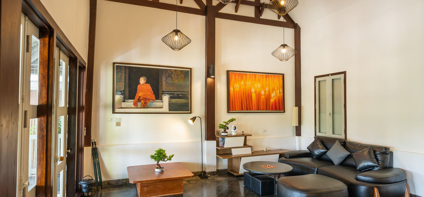 The spacious and stylish living room of the 2-bedroom private villa at MyBanLao, featuring high ceilings and contemporary Lao art