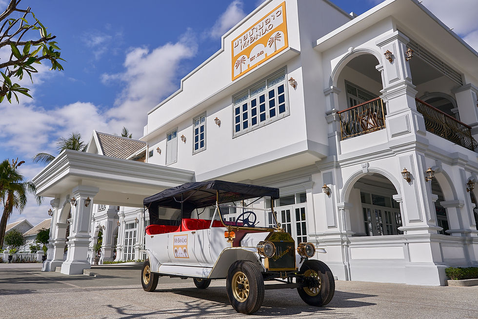 The signature vintage-style electric shuttle car waiting for guests in front of the grand entrance of MyBanLao hotel