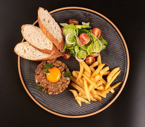 Classic French beef tartare with a fresh egg yolk, a signature dish at Bistro 1960 in Luang Prabang