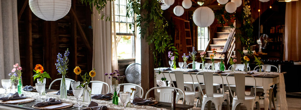 Barn interior set for guests with rustic decor and warm lighting.