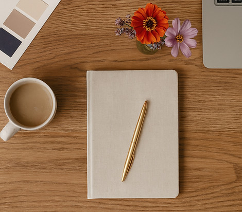 Desk flatlay with notebook, flowers, and planning materials used on the Gatherwell home page.