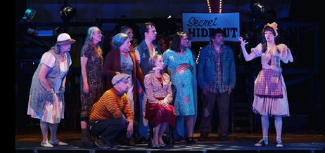 Actors in full costume performing a play on stage.