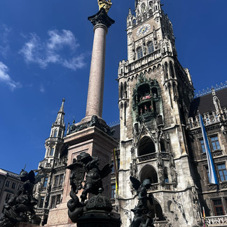 מגדל השעון המפורסם על רקע פסל Mariensäule בכיכר Marienplatz