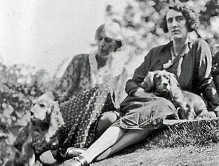Foto em preto e branco de Virginia Woolf e sua amiga, com dois cães da raça cocker speniel