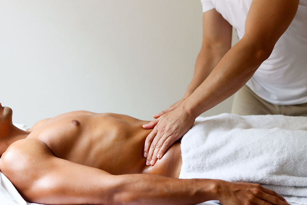 Jeune massothérapeute de beauté Asiatique réalise un massage de drainage lymphatique sur un homme musclé. En utilisant ses mains pour masser le ventre du client. 