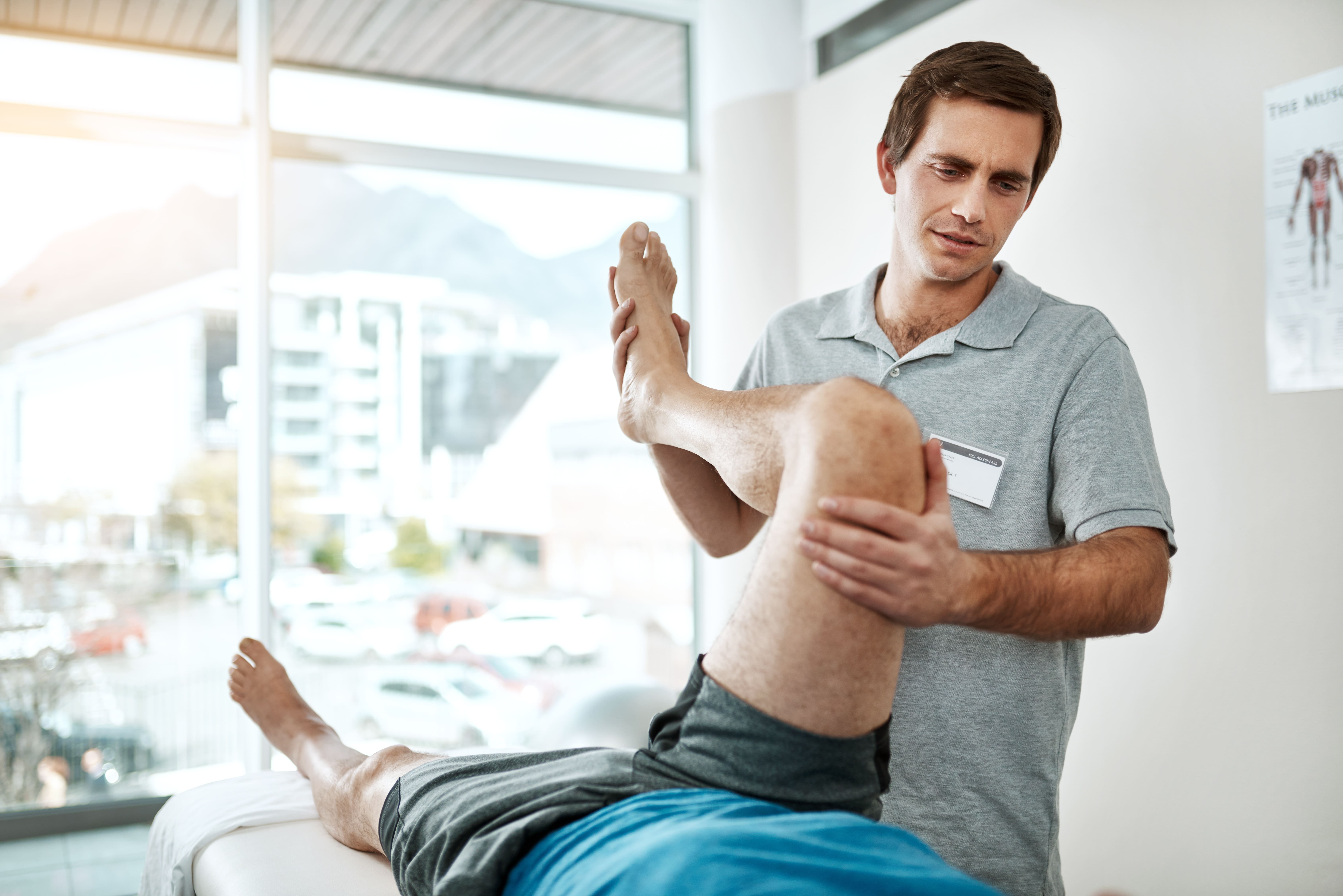 Genou, homme ou physiothérapeute avec réadaptation des jambes au bureau pour les blessures avec assistance orthopédique. Guérison, mobilité ou sport professionnel avec service de physiothérapie pour la récupération musculaire ou l'aide