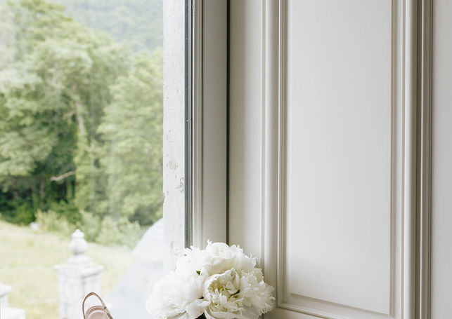 Bouquet de mariée et accessoires préparés près d'une fenêtre