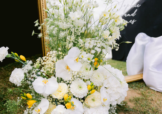Décoration florale de cérémonie avec fleurs blanches et feuillages