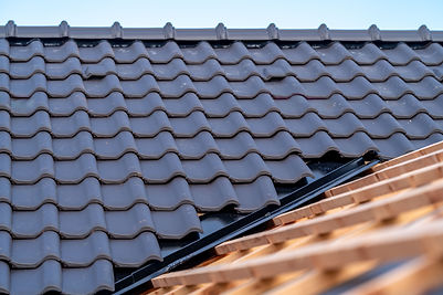 construction du toit d'une maison de famille, poutres en bois et carreaux en céramique