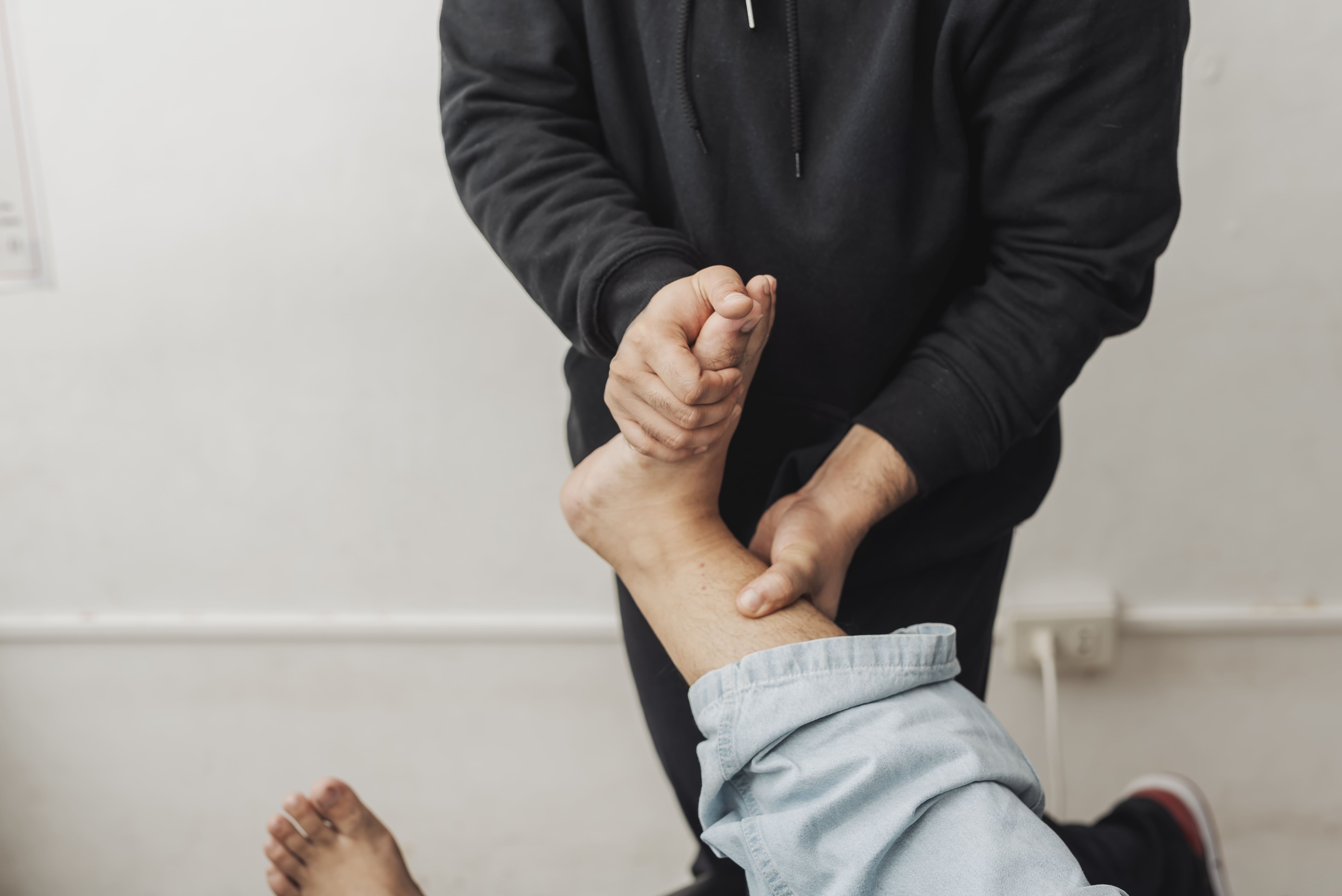 Le jeune patient reçoit un ajustement chiropratique de la cheville et une manipulation articulaire pour améliorer la mobilité, l'alignement et la fonction des membres inférieurs.