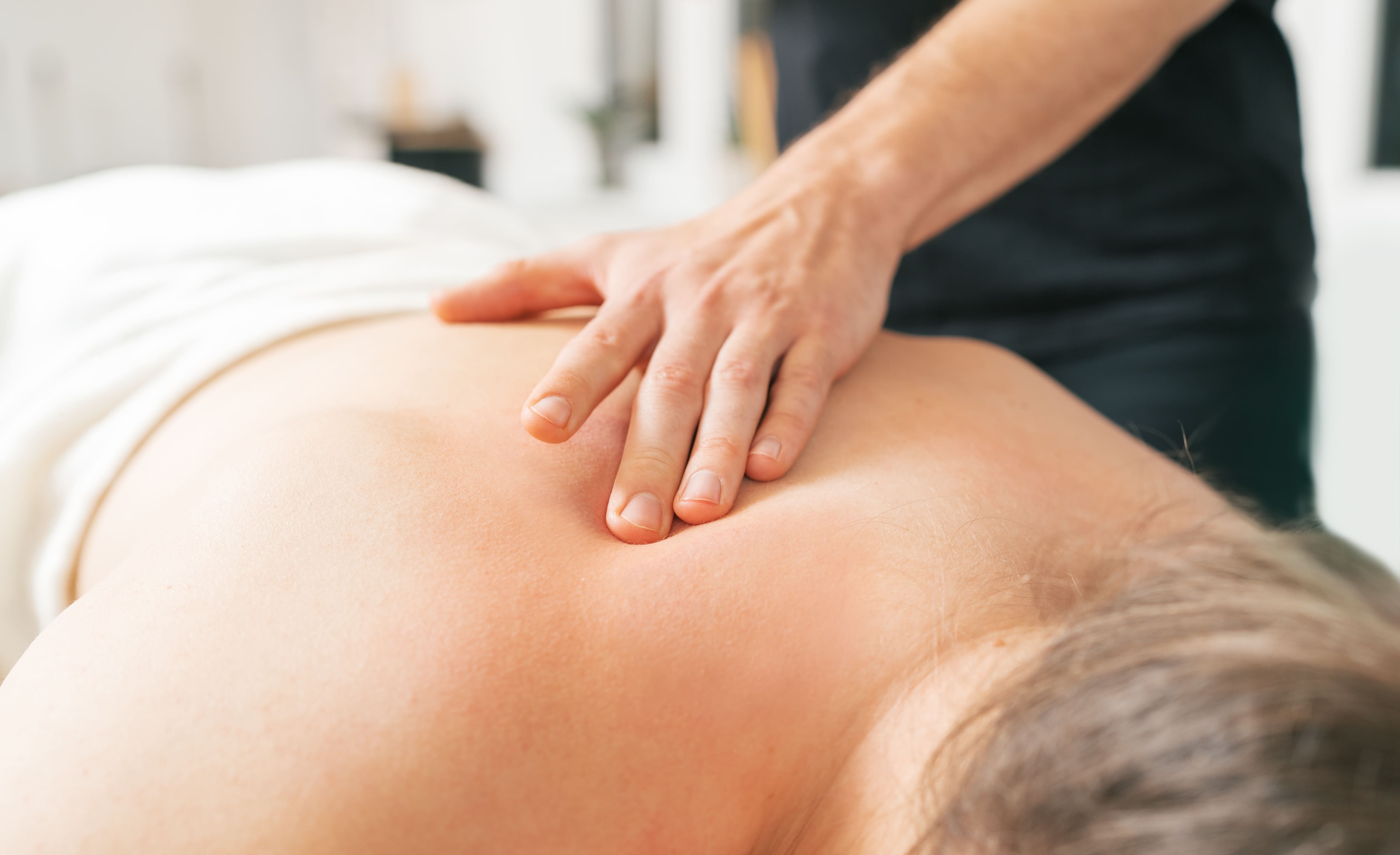 Les mains du thérapeute massent doucement la zone du cou et des épaules du patient. L'Image met en évidence la relaxation, la médecine soins pratiques en clinique. Concept d'Image santé et soins du corps.