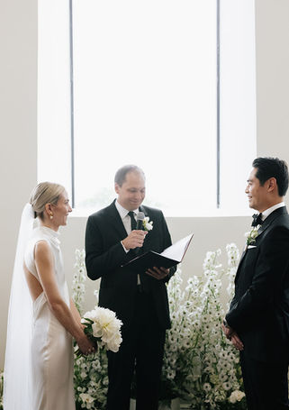 Cérémonie de mariage entourée d'une scénographie florale blanche