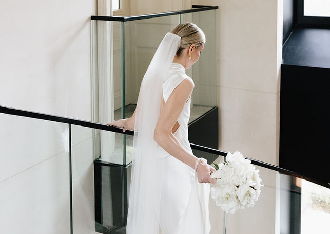 Mariée tenant un bouquet blanc dans un intérieur contemporain