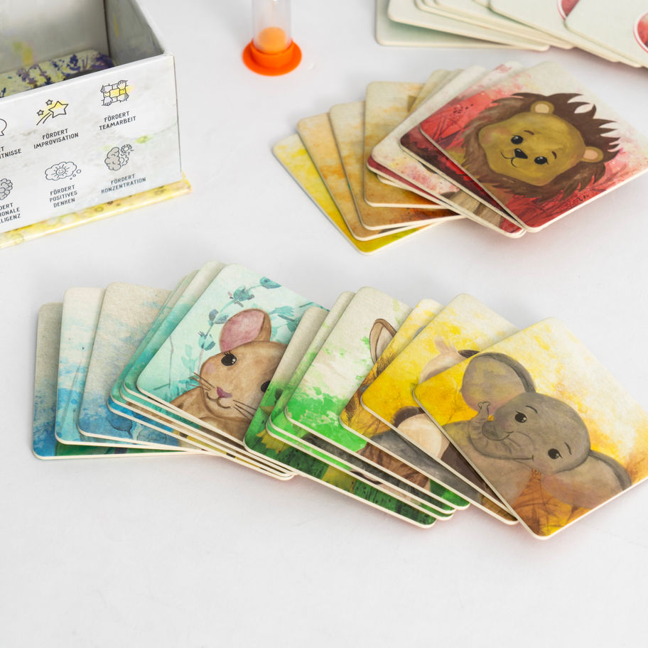 Tierkarten liegen verstreut mit kleinen Helden. Superkräfte-Komplettset – Spiel, Karten & Sticker