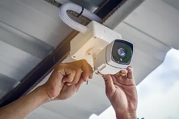Technician installing CCTV Camera under roof overhang.webp