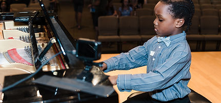 young-boy-playing-piano-at-recital.jpeg