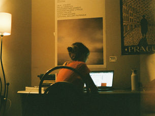 Young woman sitting at a desk writing on a laptop