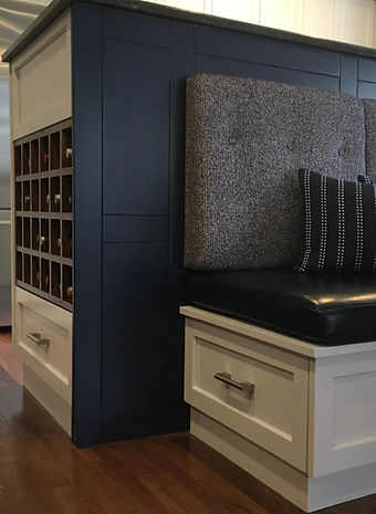 Custom kitchen completed with walnut wine rack, white custom cabinetry with brushed silver hardware. Navy banquette seating