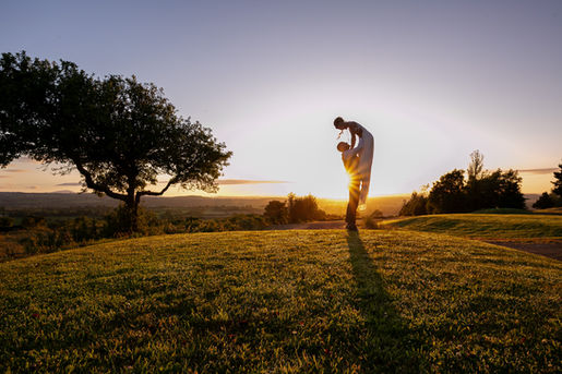 a groom lifting his bride and catching the sunset light