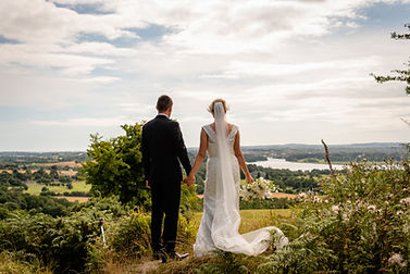 Bride and groom standing in a field in the summer sun in waterford