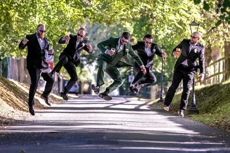 groom and groomsmen jumping with guiness