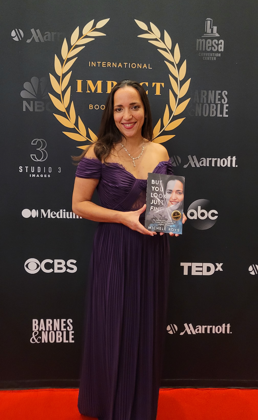 Award Winning Author - Michele Roys - holding her book at the International Impact Awards Gala