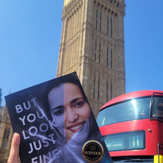 Michele Roys holding her book in London besides iconic Big Ben with a Red bus on the background