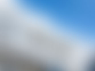 Foton logo on a white sign against a blue sky with clouds.