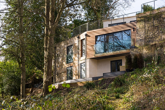 Cladding covered facade with tall windows and glass balconies