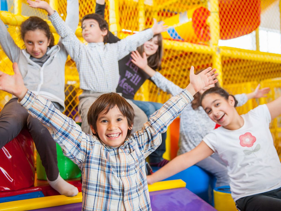 Children smiling and playing together at an indoor playground in Greenville