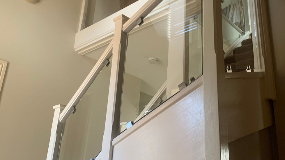 White timber staircase with glass panels secured by clamps