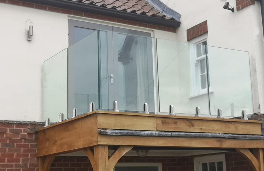 oak balcony with frameless glass balustrade using stainless steel spigots