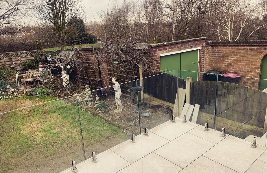 derbyshire frameless glass balustrade installed with stainless steel spigots onto porcelain raised patio