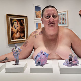 Kristine Schomaker standing nude in a gallery of nude images of herself. Perceive Me Exhibition San Diego, CA