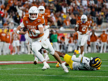 Arch Manning #16 of the Texas Longhorns runs with the ball during the Cheez-It Citrus Bowl game between the Michigan Wolverines and the Texas Longhorns