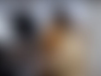 A woman in a yellow sweater reads sheet music while playing a piano.