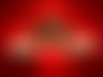 A blonde woman wearing a red dress poses with hands on her summer hat while smiling against a red background.