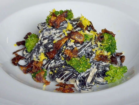 Siyah spagetti, limon ve karamelize soğan bazında yumuşak ama dikkat çekici bir tabakta buluşuyor. Üzerinde minik brokoli çiçekleri, altta parmesanlı ricotta sosu… Tabağın hem rengi hem tadı dengede. 🍋🖤🥦