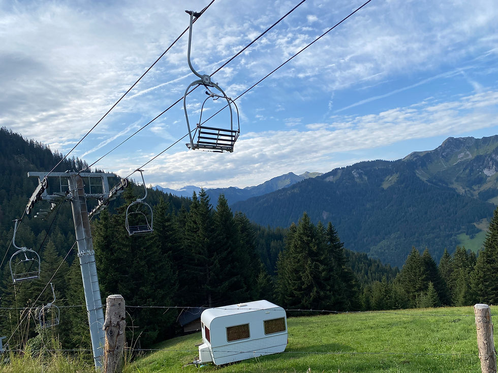 Tiny caravan below a ski lift in summer