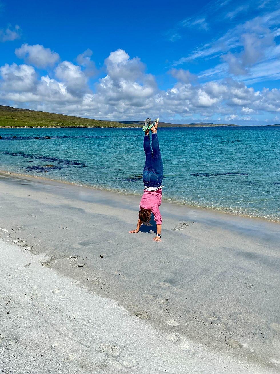 woman doing a handstand on a beach
