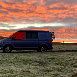 VW campervan under sunrise skies