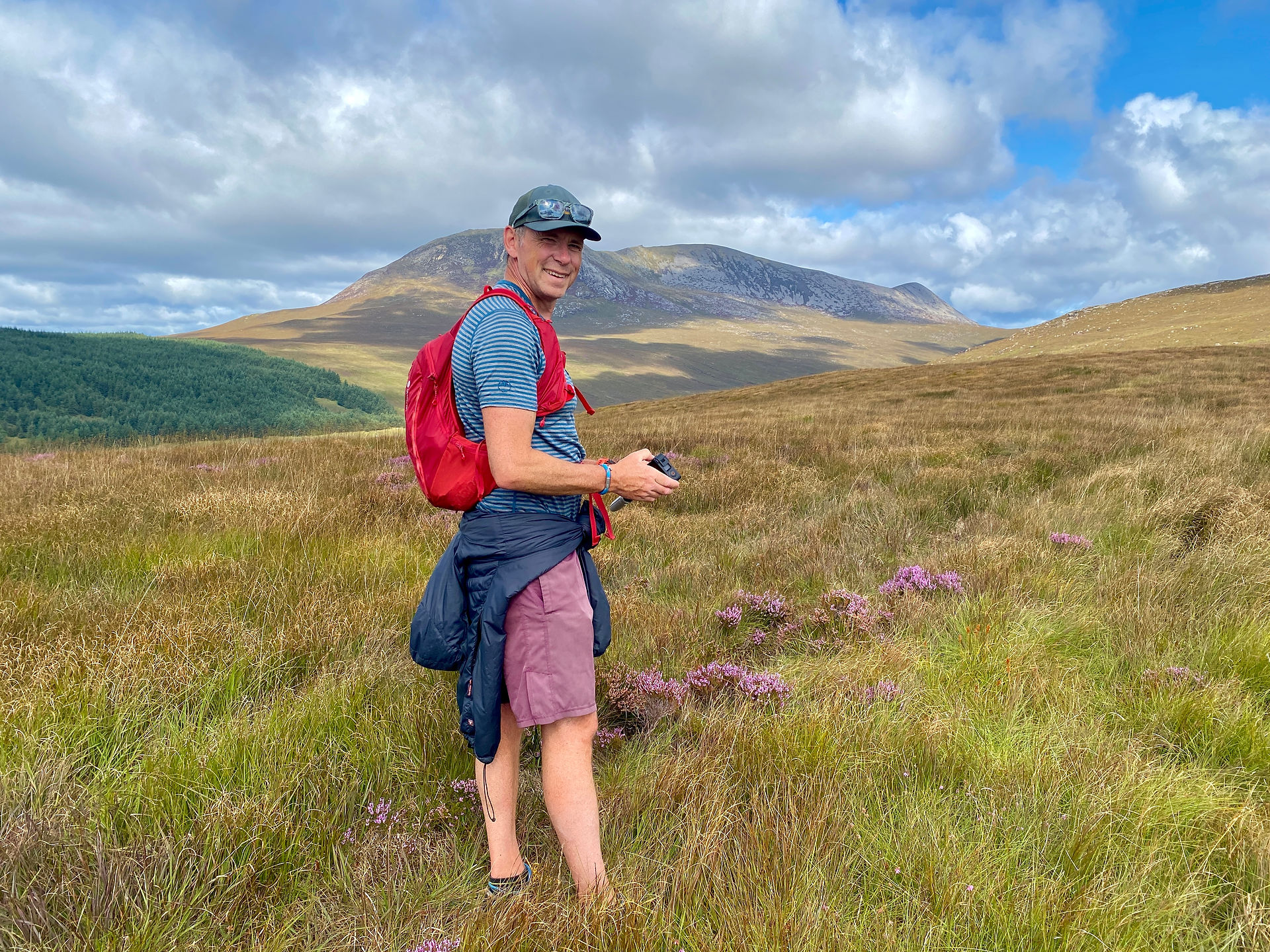 man standing in heather moorland 