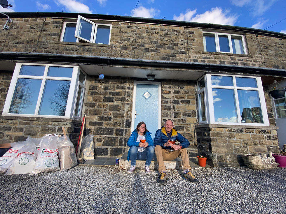Couple sat in front of renovation cottage