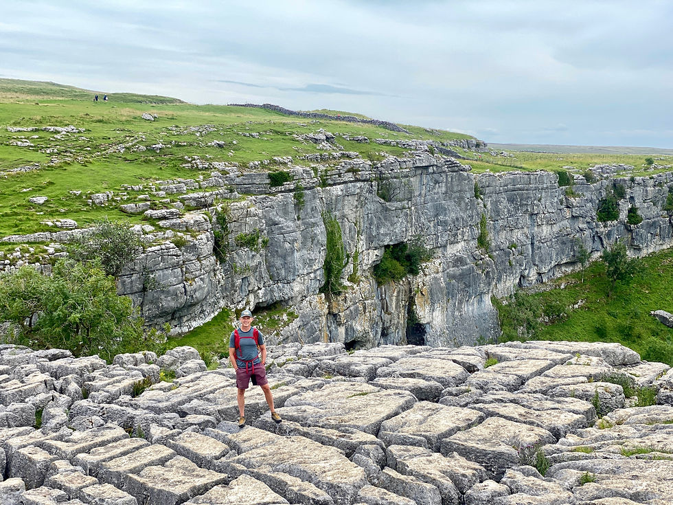 man standing on limestone pavement at Malham Cove