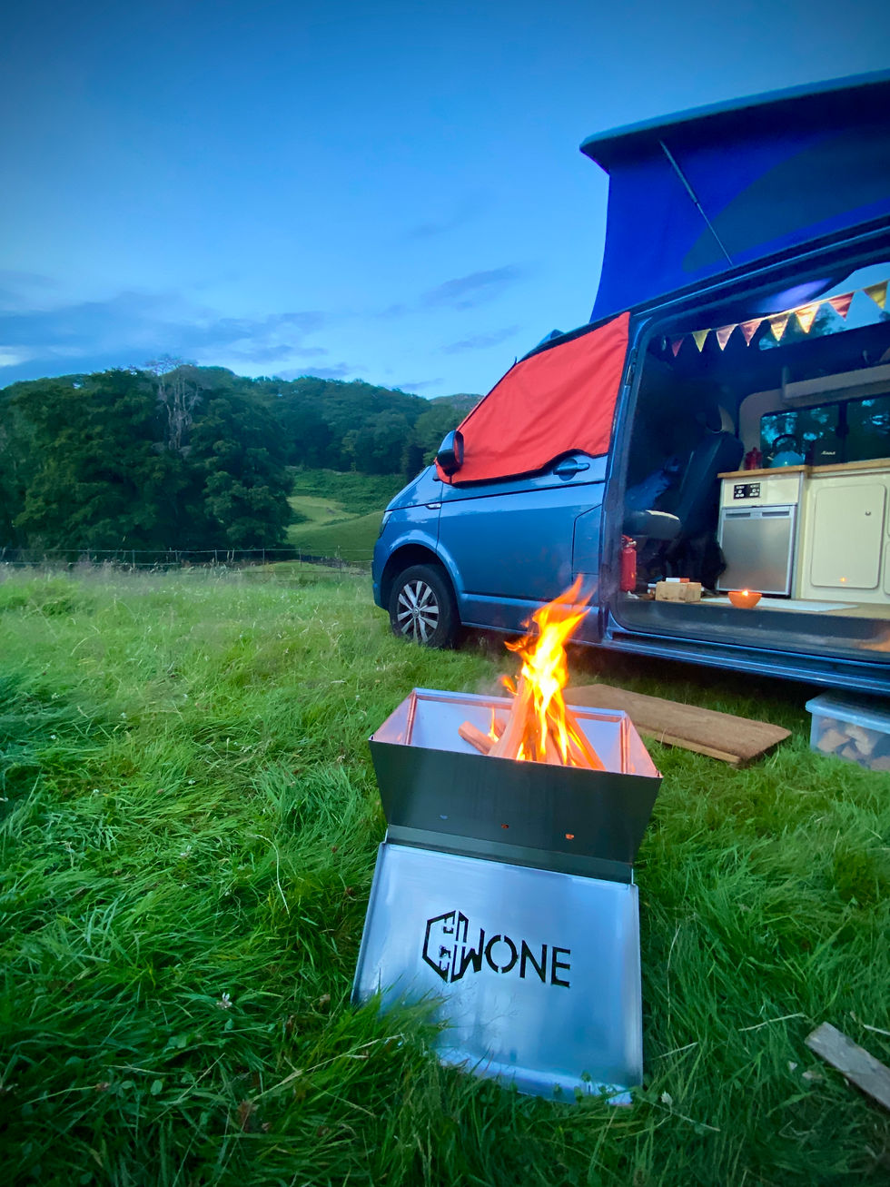 VW campervan with campfire at sunset