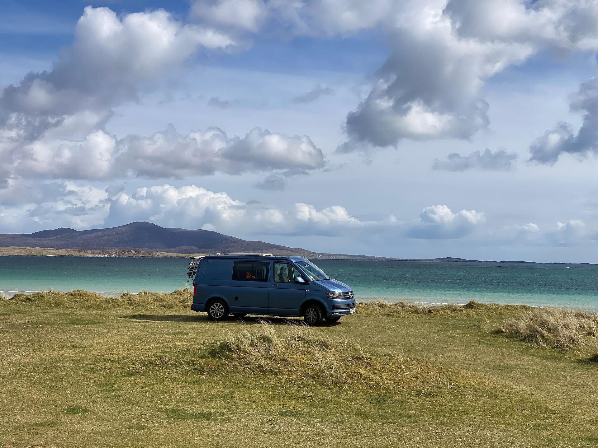 blue vw camp with sea in background 