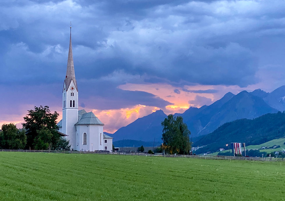 Austrian church and meadows at sunset